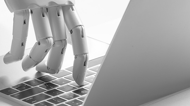 Robot handing pressing key on laptop computer